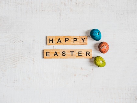 Wooden letters of the alphabet in the form of the words HAPPY EASTER on a white, isolated background. Top view, close-up. Congratulations for loved ones, relatives, friends and colleaguesの写真素材