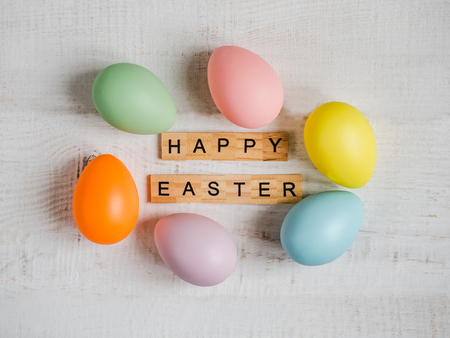 Wooden letters of the alphabet in the form of the words HAPPY EASTER on a white, isolated background. Top view, close-up. Congratulations for loved ones, relatives, friends and colleaguesの写真素材