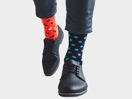 Businessman, trendy shoes, blue pants and bright, multicolored socks with a pattern of polka dots on...