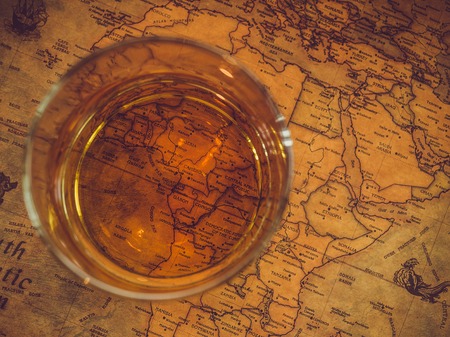 Old, vintage map and a glass of whiskey. Top view, close-up. Concept of leisure and travelの写真素材