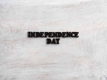 Beautiful greeting card for Independence Day. Wooden letters with a congratulatory inscription on a white background. Close-up, top view. Congratulations for loved ones, relatives, friends, colleaguesの写真素材