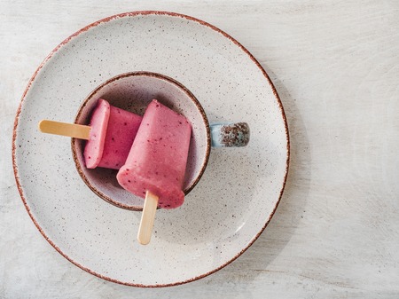 Pink fruit ice cream on a vintage plate. Close-up, top view. Concept of tasty and healthy foodの写真素材
