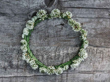 Beautiful flowers of clover lying on unpainted boards. Solemn event. Place for your inscription. Top view, close-up. Congratulations to loved ones, family, relatives, friends and colleaguesの写真素材