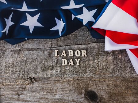 LABOR DAY. American Flag and wooden letters lying on the desk. Top view, close-up. Congratulations...