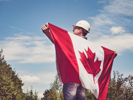 Engineer, holding Canadian Flag in the parkの写真素材
