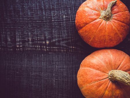 Ripe, bright pumpkin lying on a wooden surface. Place for your inscription. Top view, close-up. Congratulations to loved ones, family, relatives, friends and colleaguesの写真素材