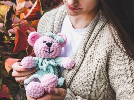 Pretty, young woman holding a stuffed toy in the background of yellow foliage. Close-up, outsideの写真素材