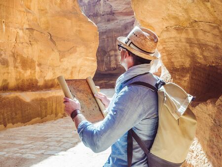 Handsome man, exploring the sights of the ancient, fabulous city of Petra in Jordan. Colorful...