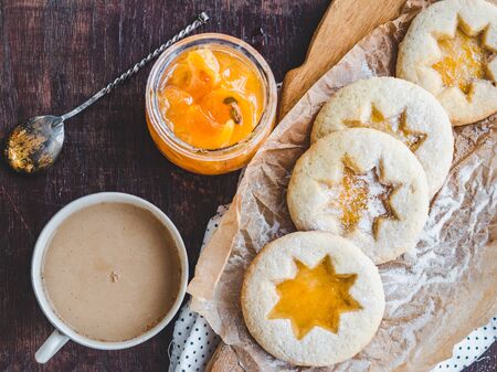 Fresh, fragrant handmade cookies, lying on a cutting board and jam of orange slices. Close-up, side view. Tasty and healthy eating conceptの写真素材