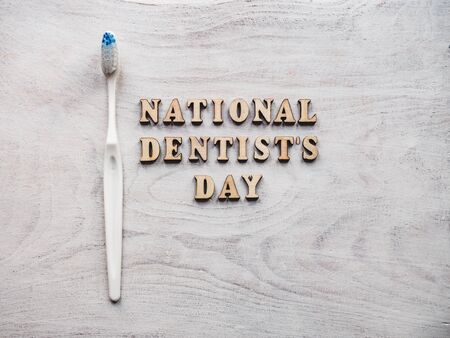 Dentist's day greeting card. White, isolated background, close-up, view from above, wooden surface. Congratulations for relatives, friends and colleaguesの写真素材