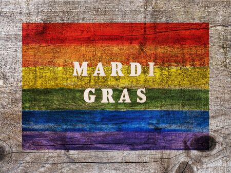 Rainbow Flag lying on an empty table. Beautiful card. Isolated background, wooden surface. Congratulations for relatives, friends and colleaguesの写真素材