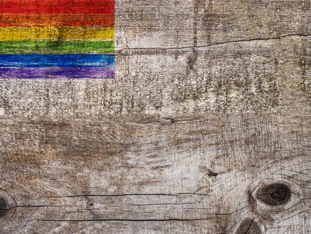 Rainbow Flag lying on an empty table. Beautiful card. Isolated background, wooden surface. Congratulations for relatives, friends and colleaguesの写真素材