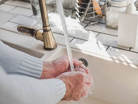 Men's hands and a bar of soap on a background of a vintage tap. Top view, closeup. Health Care and...