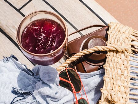 Beautiful glass with refresh wine and ice cubes on the background of the plank deck. Top view,...
