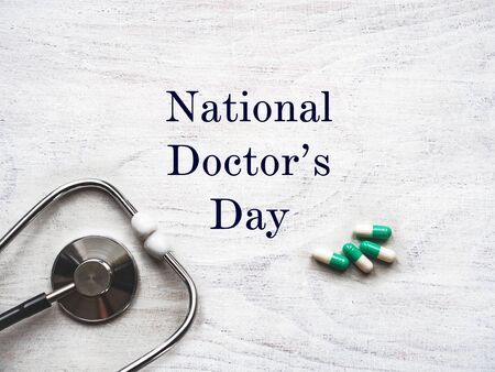 Happy national Doctor's Day. Beautiful card. Isolated background, wooden surface. Congratulations to family, relatives, friends and colleaguesの写真素材
