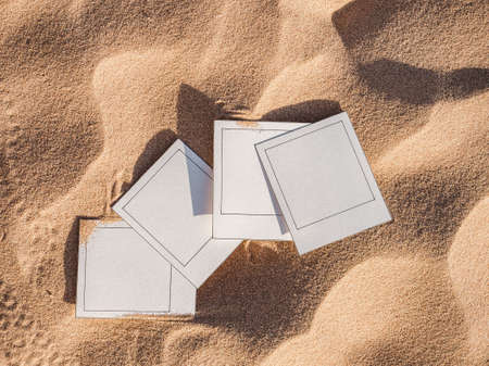 Beautiful photos lying on sand background. Close-up