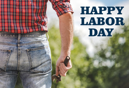 Happy Labor Day. Handsome man and congratulatory description. Closeup, outdoors. Congratulations for family, loved ones, friends and colleagues. Concept of preparation for the holidayの写真素材