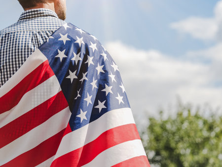 Attractive man holding American Flag. Close-up, outdoors. Congratulations for family, loved ones,...