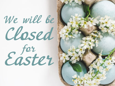 Signboard with the inscription We will be closed for Easter. Pastel blue Easter eggs on a white table with spring blossoms. Festive Easter and spring celebration concept. Close-up, studio shotの写真素材