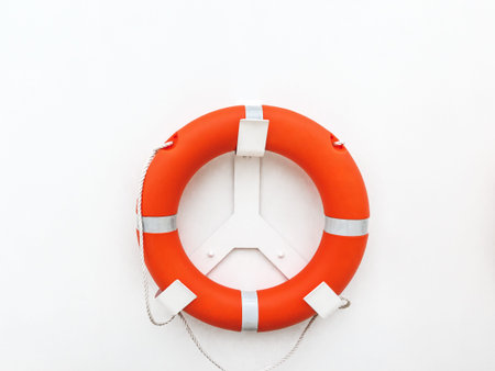 Orange lifebuoy with white bracket on clean white background. Cruise ship safety and maritime rescue...