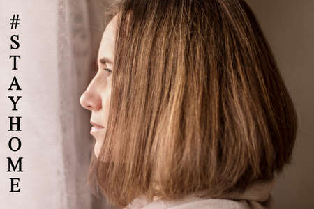 Sad girl in the kitchen in her apartment on self-isolation. Stay home in quarantine to prevent coronavirus infection. Covid-19 Pandemic 2020.の写真素材