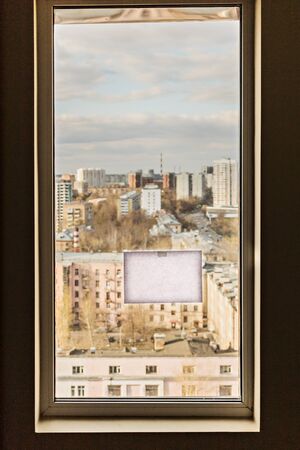 Window with a view of the city and an empty place for inscription. Importance of staying at home self-isolation to prevent coronavirus infection. Home quarantine concept. Pandemicの写真素材