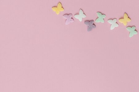 Pastry multicolored sprinkles-butterflies are laid out in the form of a chain on a pink background. Decoration of confectionery products.の写真素材