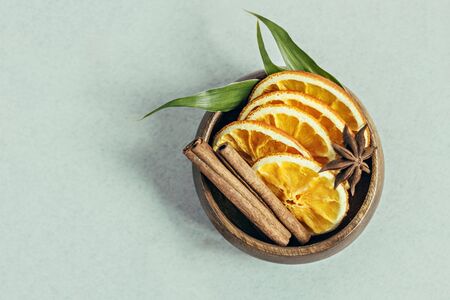 In a wooden bowl, sliced orange, cinnamon sticks on a gray background. Aromatherapy.Home spa...