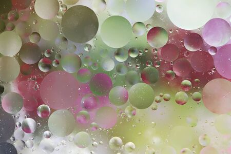 Abstract colorful background from drops of oil in water. Macro photo.