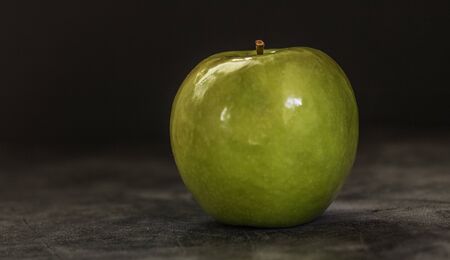Juicy fresh green apple on a dark background with space for text. Banner.の写真素材