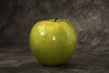 Juicy fresh green apple on a dark background with space for text. Banner.の写真素材