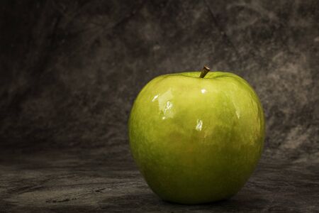Juicy fresh green apple on a dark background with space for text. Banner.の写真素材
