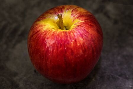 Juicy fresh red apple with water droplets on a dark background with space for textの写真素材