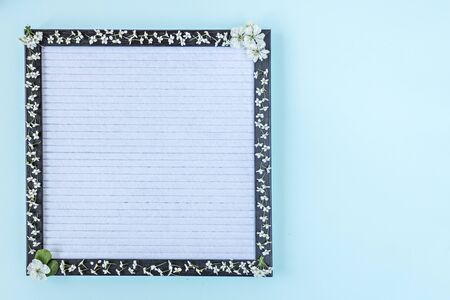 Blank writing board decorated with white small flowers. Place for text. Banner.の写真素材
