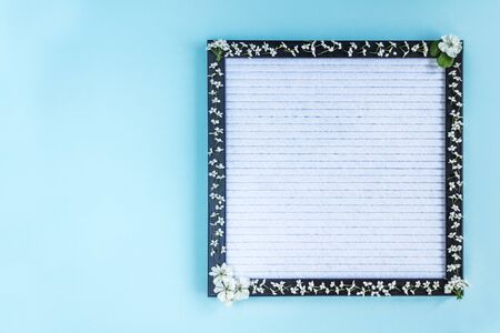 Blank writing board decorated with white small flowers. Place for text. Banner.の写真素材