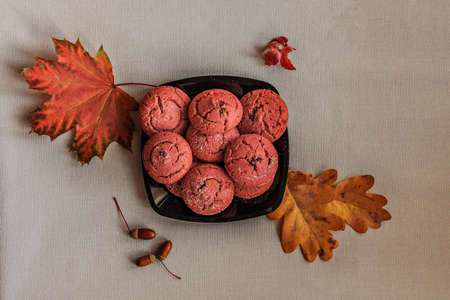 Cranberry cookies in a black plate with colorful autumn leaves on a blue background. Autumn concept. Top viewの写真素材