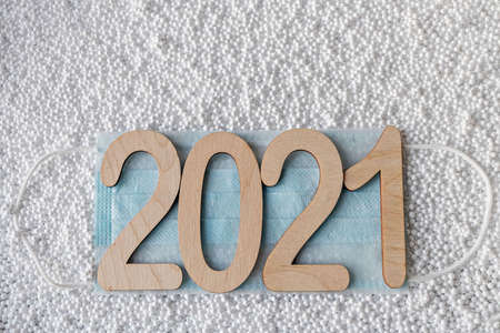 Number 2021 with fir branches on a white snowy background. Concept of Christmas and New Year.