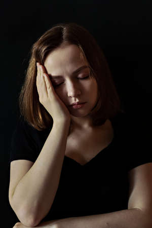 A girl in a black t-shirt with a pink ribbon on her chest is fighting cancer. Breast cancer awareness month. The concept of breast cancerの写真素材