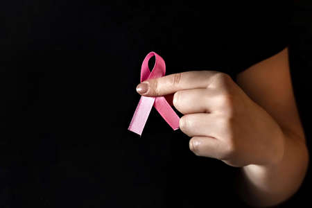 A girl in a black t-shirt with a pink ribbon on her chest is fighting cancer. Breast cancer...