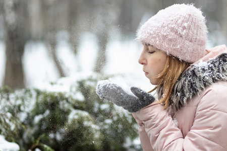 Portrait of a young woman in warm winter clothes outdoors while traveling. Winter time, snow.の写真素材