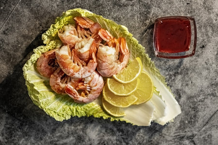 On the leaves of Peking cabbage, king prawns with lingonberry sauce and lemon. The concept of healthy eating.の写真素材