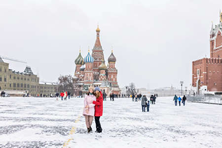 A beautiful young girls walks along Red Square in Moscow during a snowfall and blizzard.のeditorial素材