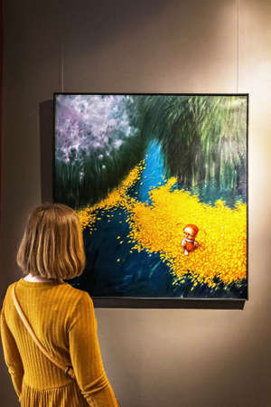 Young woman looking at a painting in an art gallery.