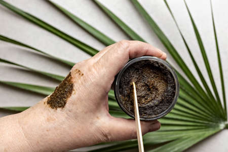 In a woman's hand is a jar with a Body Scrub made from natural ingredients. Handmade cosmetics. Home spaの写真素材