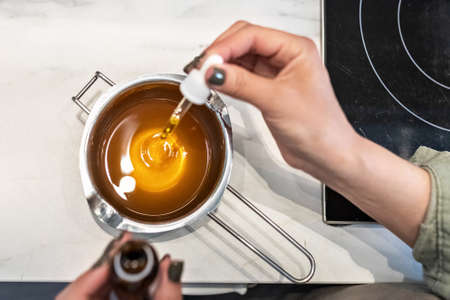 Top view of hot cocoa butter melted in a water bath for making body skin care cosmetics. The cooking process, the addition of aromatic oils. Home spa. Small business.の写真素材