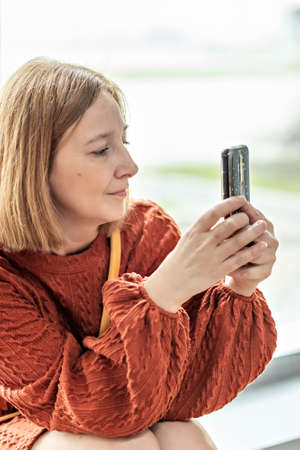A young woman takes a photo on a smartphone, takes a video.の写真素材