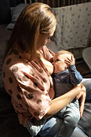 A young woman is breastfeeding her little son. Breastfeeding, motherhood. Family.