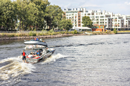 A young woman rides on a water board attached to a boat on the river.の写真素材