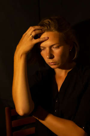 Portrait of a young sad woman in depression, stress. Mental health.Dark key.の写真素材