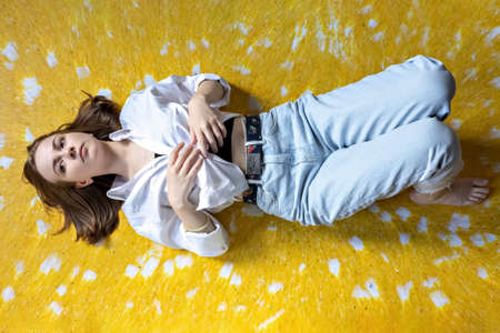 Portrait of a young teenage girl lying on the floor. Stress, depression, relaxation. Mental health.の写真素材